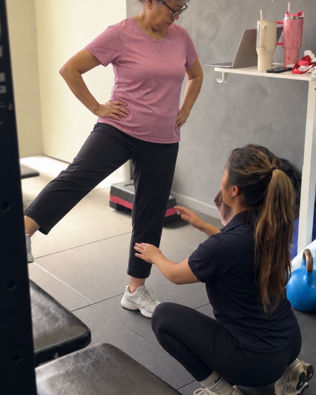 Physiotherapist guiding a patient through a side leg raise balance exercise in the osteoporosis exercise program at Tensegrity Clinics St Leonards